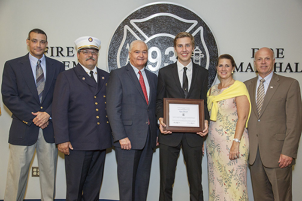 Ryan Devosa of Ramtown Fire Company in Howell is presented with the Class 106 Ronald Fitzpatrick Firefighter 1 Award at the Monmouth County Fire Academy graduation on June 23, 2015 in Howell, NJ. Pictured left to right:  Fire Academy Director Armand Guzzi, Monmouth County Fire Marshal Henry Stryker III, Freeholder John P. Curley, Ryan Devosa, Freeholder Deputy Director Serena DiMaso and Freeholder Director Gary J. Rich, Sr.